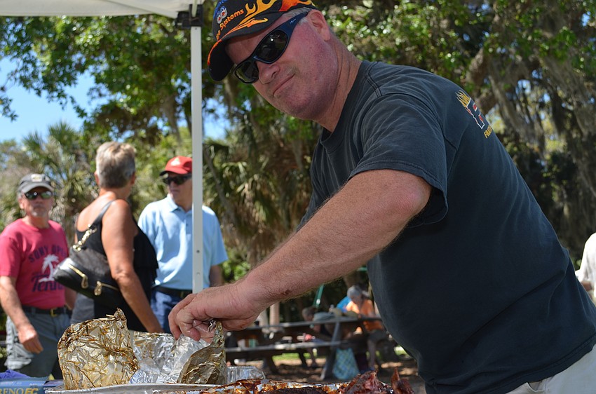 Paul Dyer prepares ribs from Station 18 for attendees to sample.