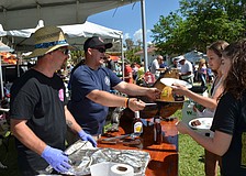 Sam Johnson and Matthew Petitt serve ribs from station Venice Fire Rescue.