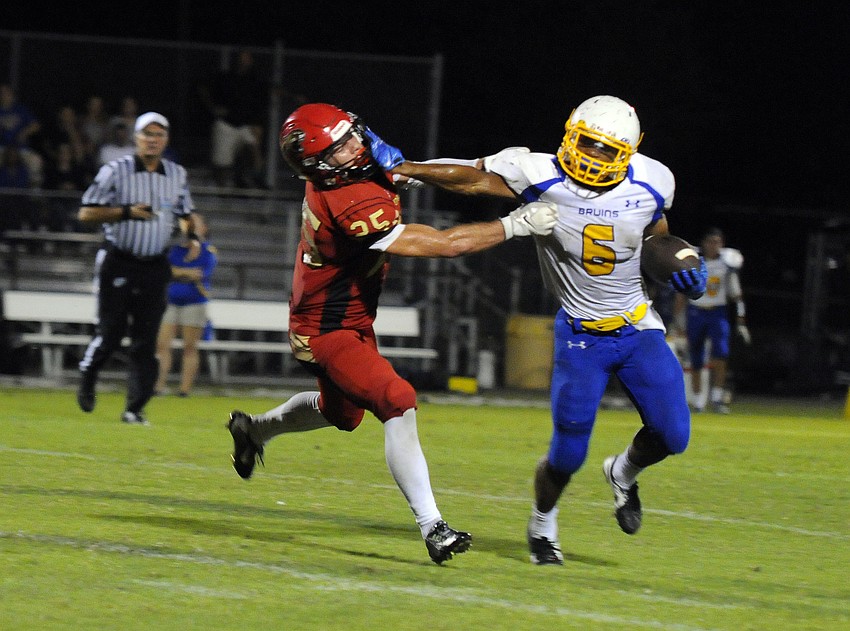Cardinal Mooney linebacker Vinny Conetta attempts to tackle Bayshore running back A'shawn Angell.