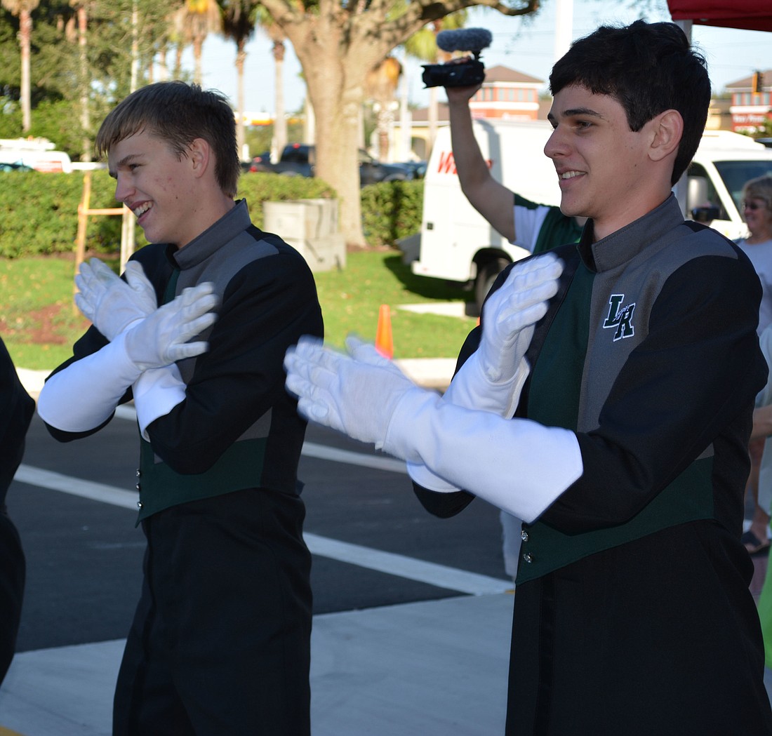 Aaron Harshman and Alex Vehling, both juniors at Lakewood Ranch High, do a little dancing when they aren't playing their trombones at Wawa's opening.