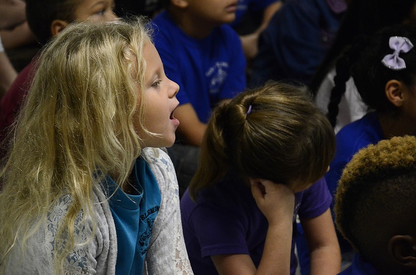 First-grader Alexa Anspach sings during the program.