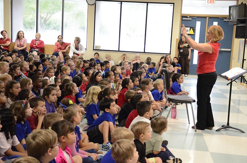 Music teacher Barbara Sifferman guides younger grades through a sing-along during the fourth-graders performance.