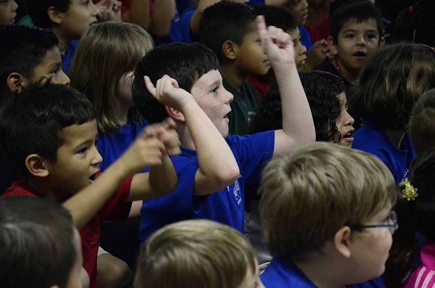 First-grader Carter White sings along during the program.