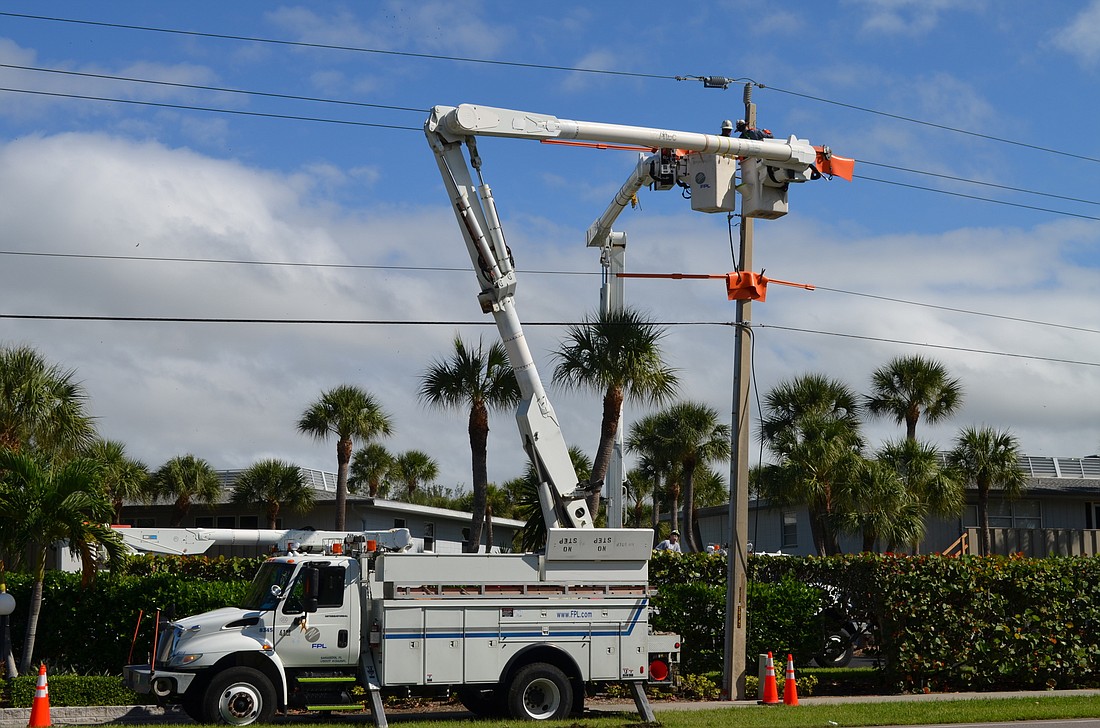 Florida Power & Light Co. crew members work to repair a power line in the 6700 block of Gulf of Mexico Drive Monday in an area that Commissioner Pat Zunz says has frequent power outages that arenâ€™t documented. (Kurt Schultheis)