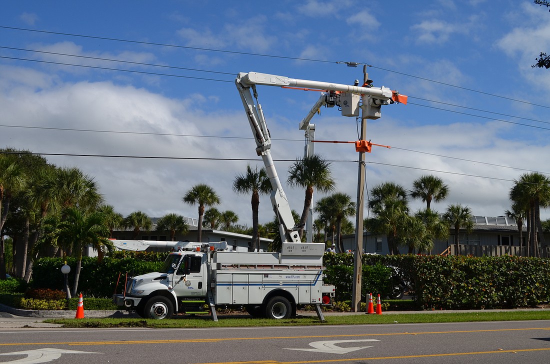 Florida Power & Light Co. crew members work to repair a power line in the 6700 block of Gulf of Mexico Drive Monday in an area that Commissioner Pat Zunz says has frequent power outages that arenâ€™t documented. (Kurt Schultheis)