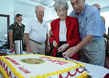 Guest of Honor and WWII Marine veteran Blanche Mettler makes the first slice of the cake with help from Joe Tomaselli.