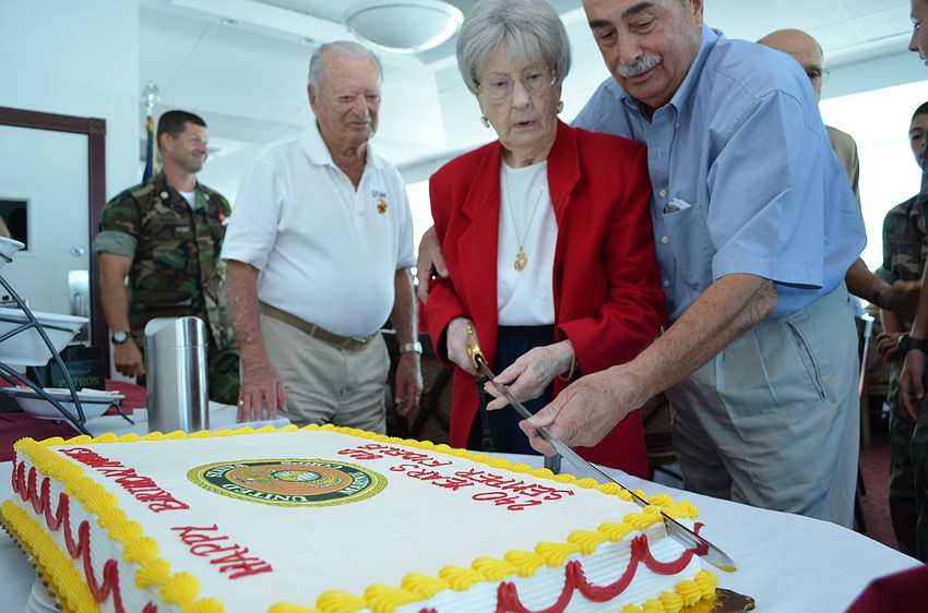 Guest of Honor and WWII Marine veteran Blanche Mettler makes the first slice of the cake with help from Joe Tomaselli.