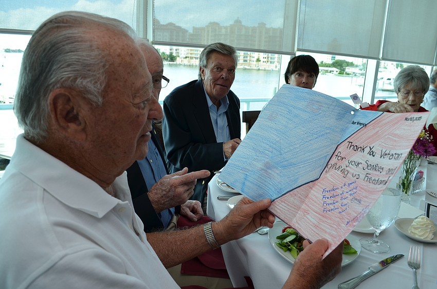 Ralph Franklin reads a card left at the table thanking veterans for their service.