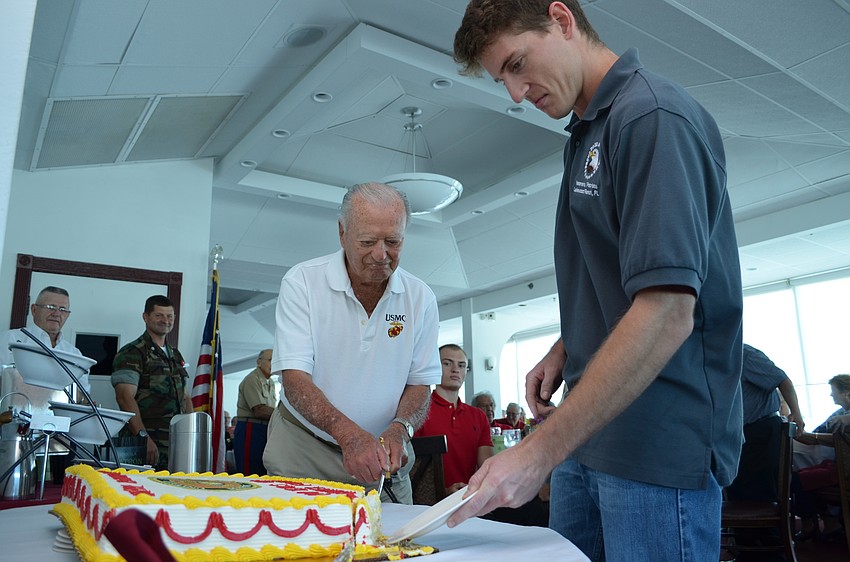 Per tradition the oldest Marine in attendance slices a piece of the cake and gives it to the youngest attendee.