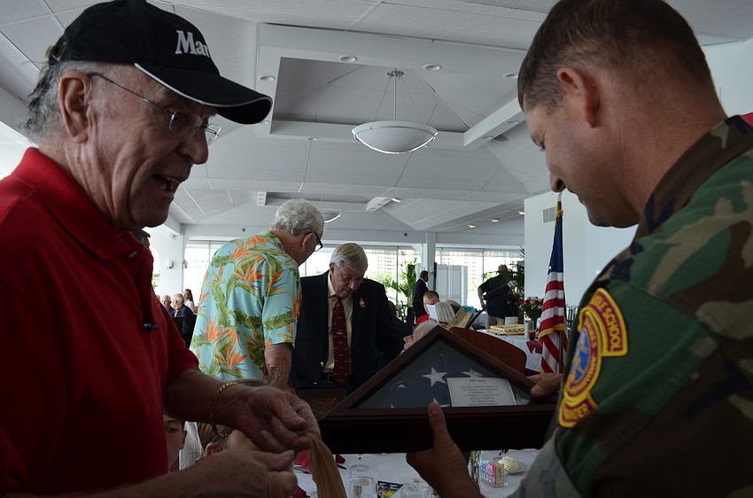 Time Downey gives a folded flag and some of his favorite books about Marines to Maj. Mike Dubrule.