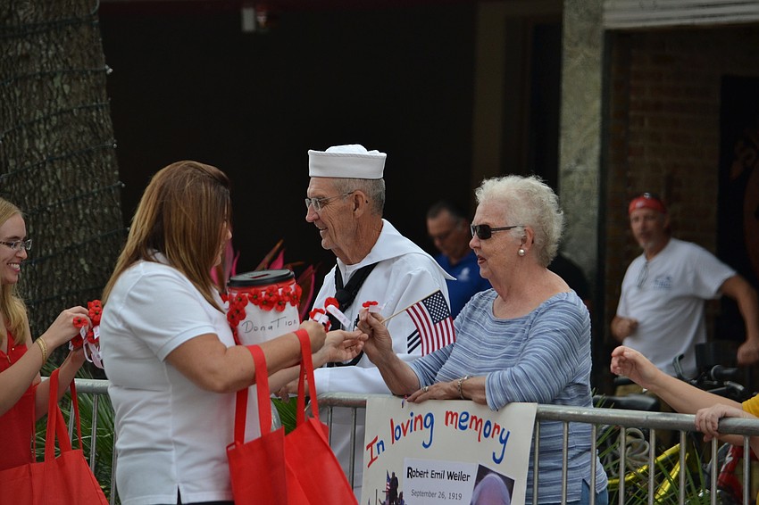 Dennis and Meryl Hauck receive poppies and flags during the parade.