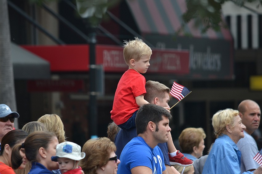 Brody Johnson catches a ride on his father Todd Johnson's shoulders to get a better view of the parade.