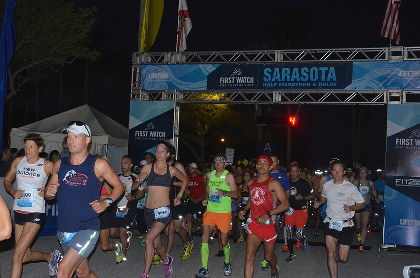Runners cross the start line.