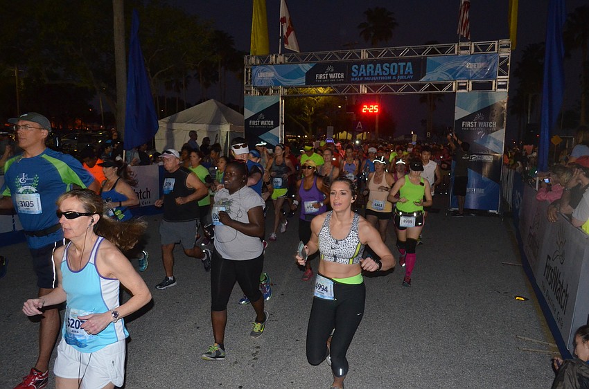 Runners cross the start line.
