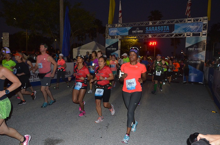 Runners cross the start line.