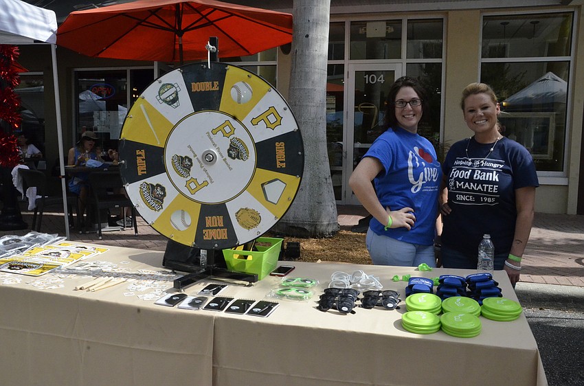 Angela Salazar and Jessica Cary, volunteers from Publix, give out prizes to wheel spinners.