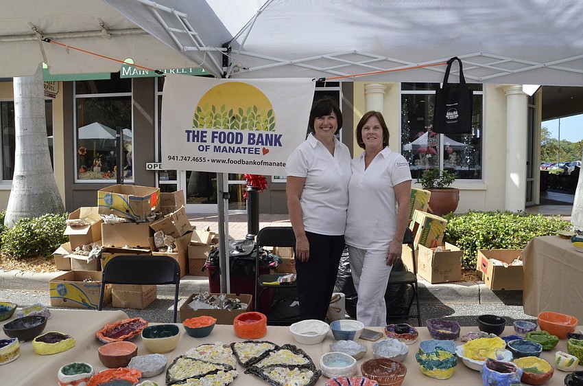Cheryl Miller and Deborah Decker with Edward Jones watch over the ceramic bowls.