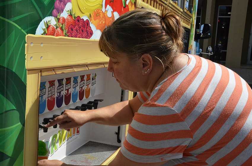 Collette Abbot-Guthrie with Turner Tree and Landscaping selects a flavor from Kona Ice.