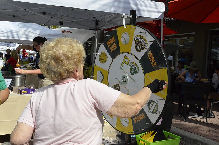 Mary Meyer, a seven-year volunteer with the food bank, spins the wheel for a prize.