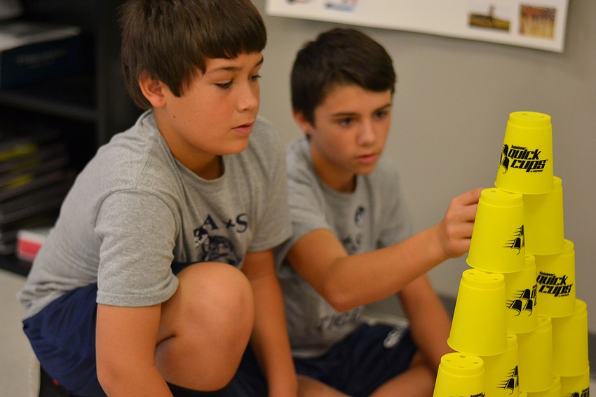 James Harrison and Justin Pugliese work together to build a cup pyramid.