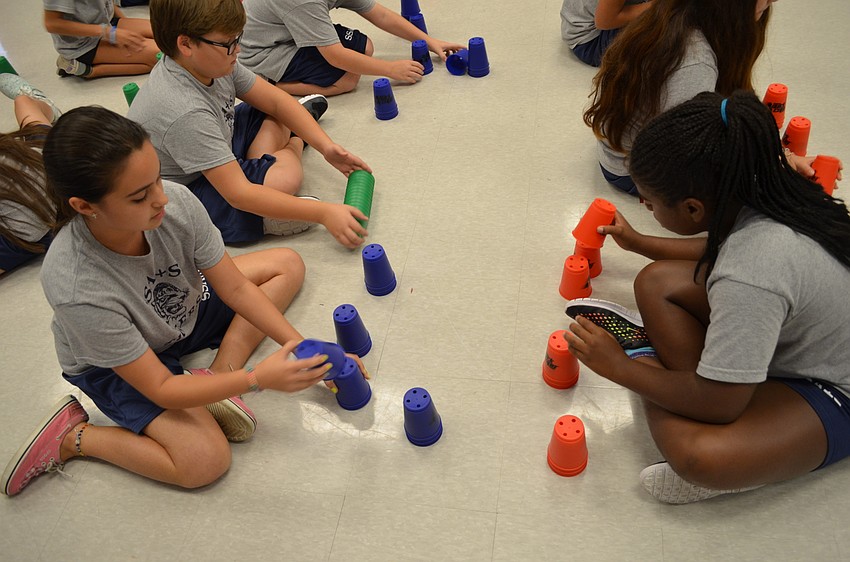 Maria Lachance and Aziya Finley work on their cup-stacking technique.