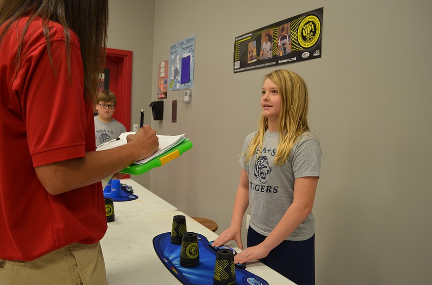 Fitness teacher Hollie Nelsen tracks Reegan Johnson's time.