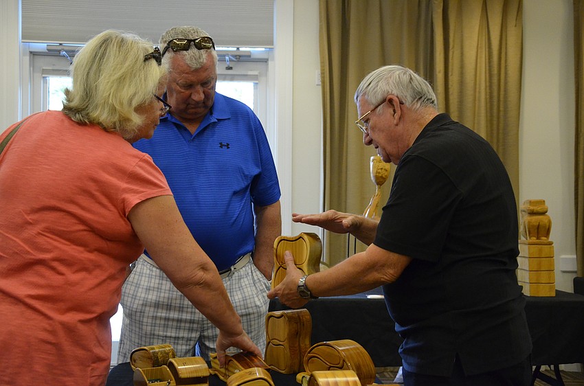 Mary Poole and Roger Gwilliams of the Meadows talk with Harry Bandish about his handcrafted wooden keepsake boxes.