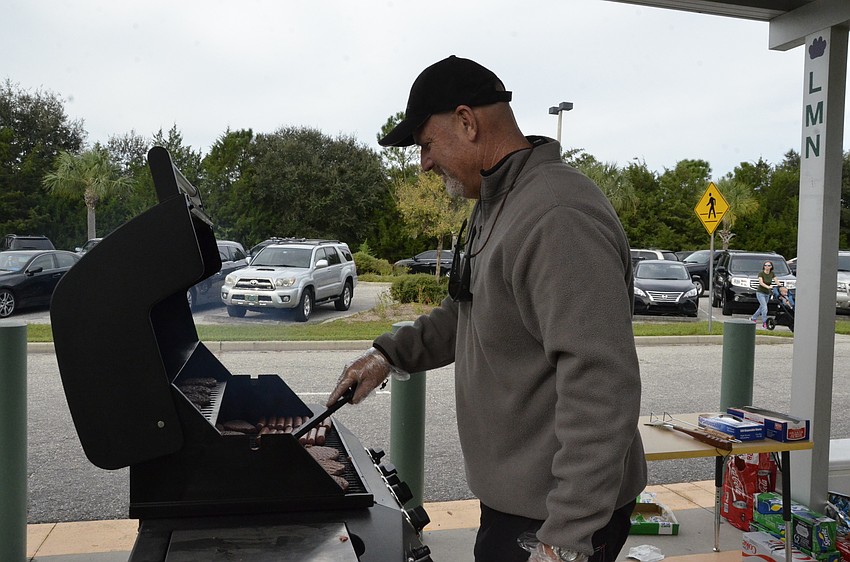 Volunteer Jim Newby cooks up some hamburgers and hotdogs.