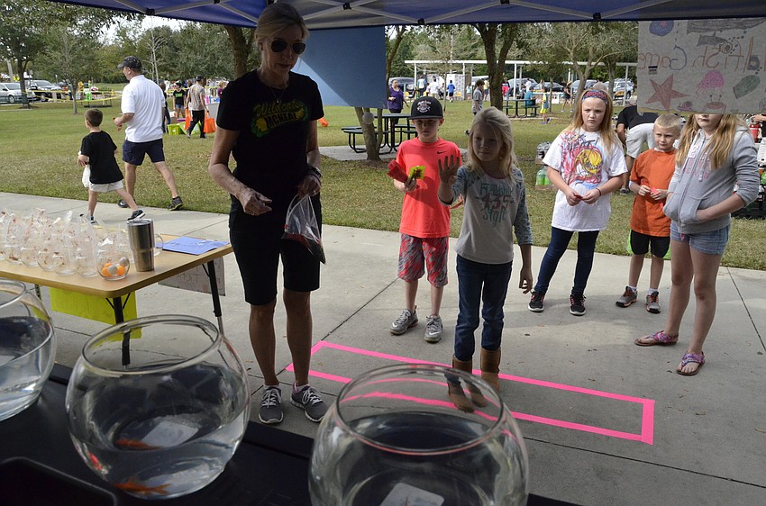 Taylor Woolever tries to win a gold fish at Mary Anne Wampole's tent.