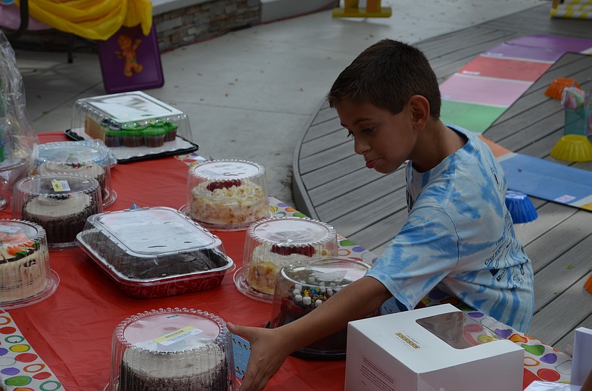 Andres Espinel picks out his prize from winning a round of the cake walk.
