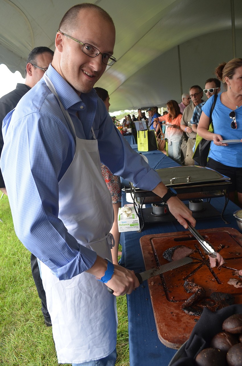 Mike Heitzman, of Sarasota, serves up slabs of meat from Michael's on East.