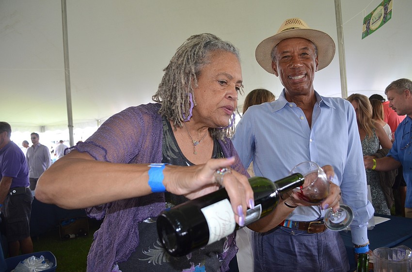 Charlayne Hunter-Gaunt serves up red wine from her African wine brand, Passages, alongside her husband, Ron.