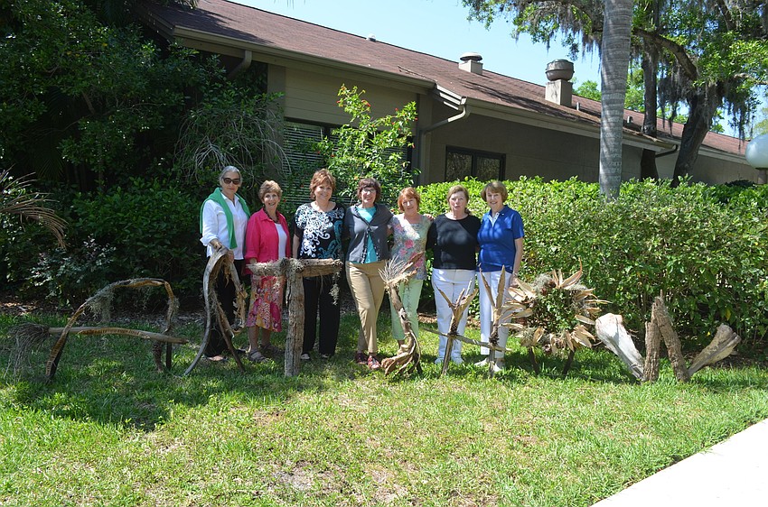 Chair of intake Karen Watt, hanging and display coordinator Merry Gerber, event co-chairs Cheryll Glowacki and Jane Freund, studio tours chair Rosemary Stackowicz, Thelma Bold and cookie co-chair Alberta Gregory pose with wooden figures spelling out “Art