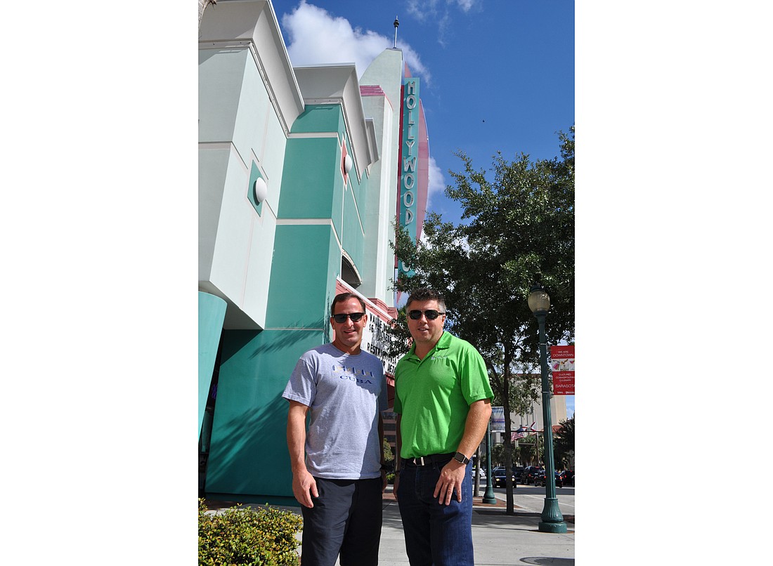 Jesse Biter and Eric Baird pose in front of the Hollywood 20 complex. They are part of a group of investors that purchased the property on Nov. 12 for $18.1 million.