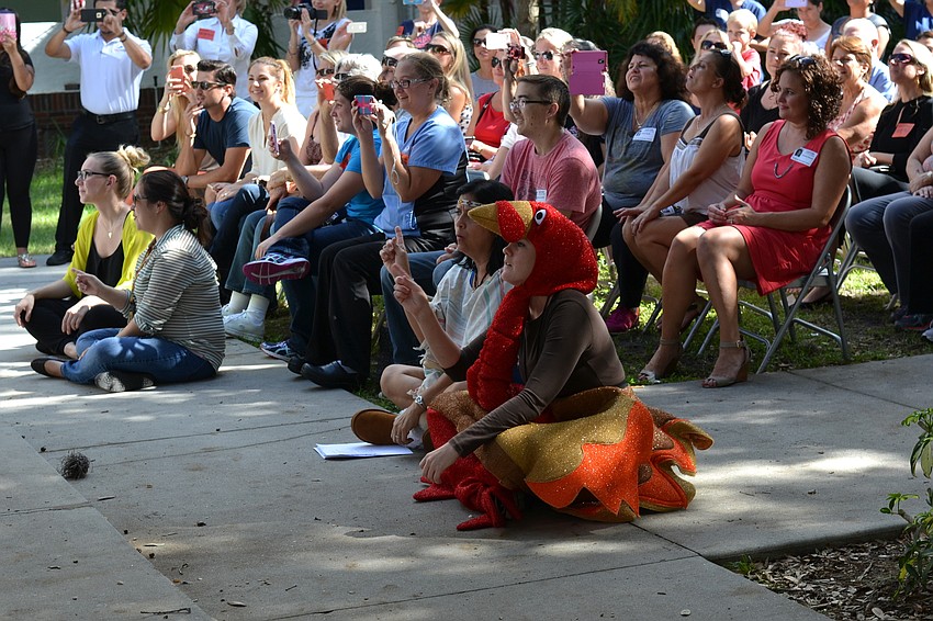Teachers Ileana Manzano and Danielle Sobolewski lead students in song dressed as a Native American and turkey.