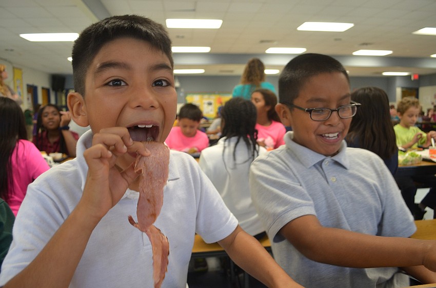 Elijah Veldez plays with his ham before taking a bite.