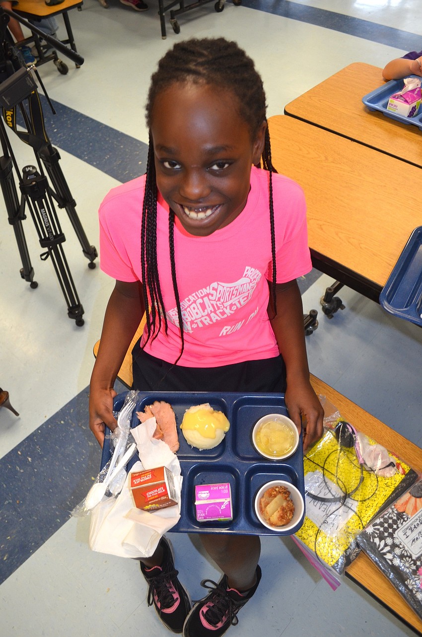 Emilie Colas, 10, enjoys ham, apple pie and other holiday fixings.