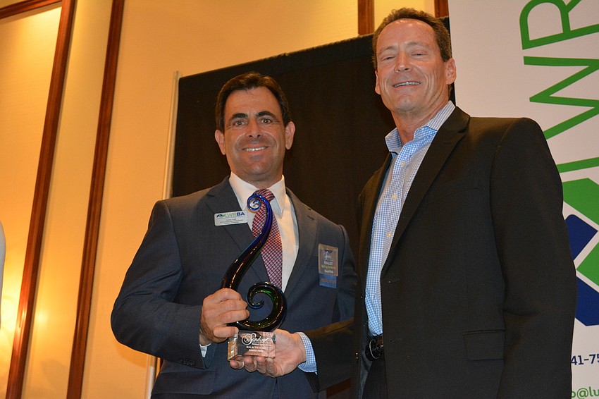 David Fink, with Halliday Financial and Friday's master of ceremonies, accepts his Bull by the Horns award from presenter Kirk Boylston, the president of Lakewood Ranch Commercial Realty.