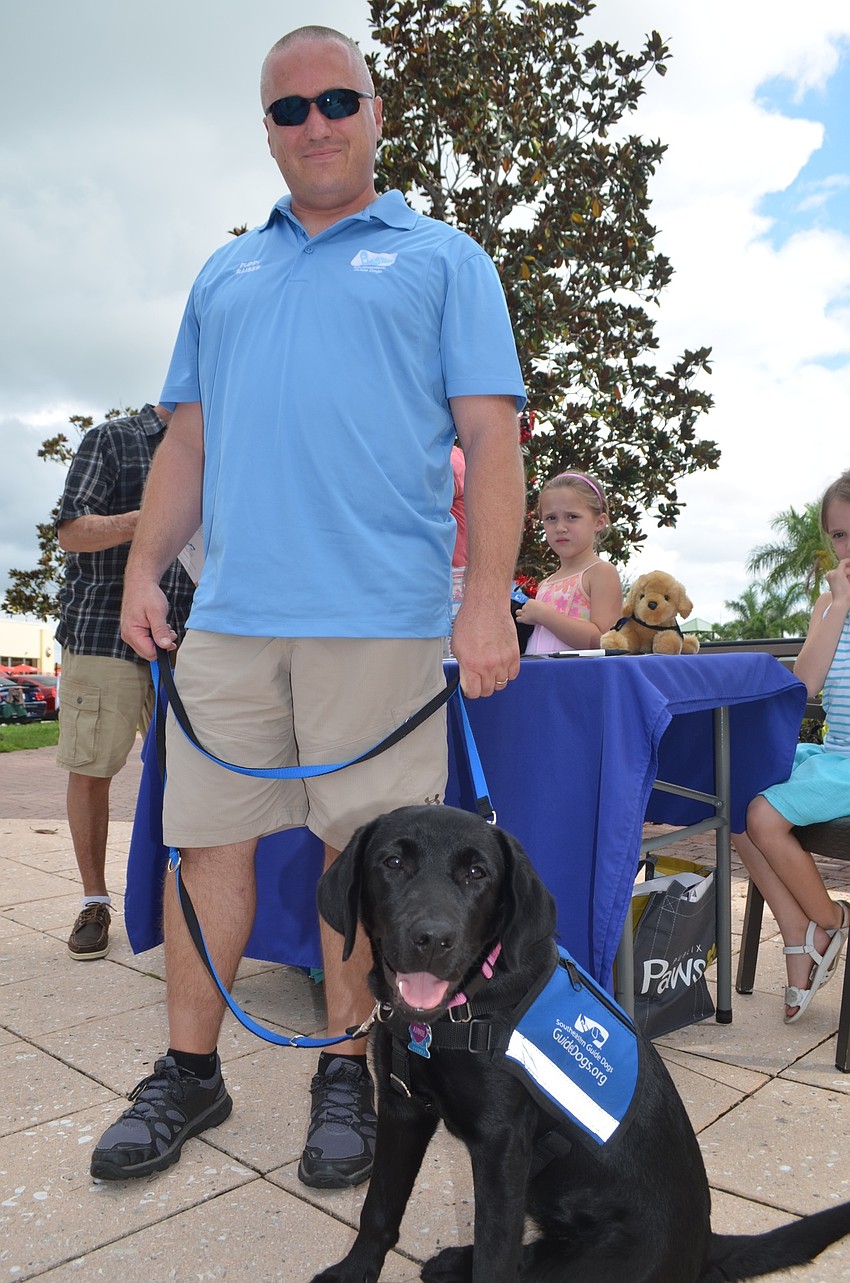 Ray Crane, of Bradenton, and Annie, a guide dog in training, represent Southeastern Guide Dogs — one of the organizations that benefited from the event.
