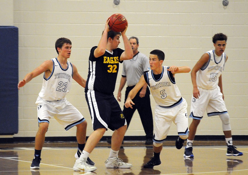 Sarasota Military Academy sophomore Garrett Gill attempts to maneuver past ODA's Todd Humphrey and Andrew Berg.