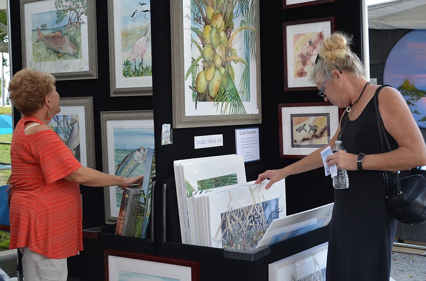 Art fans Fran Gouze and Jeanne Kelly comb through artwork by Linda Sodequist.