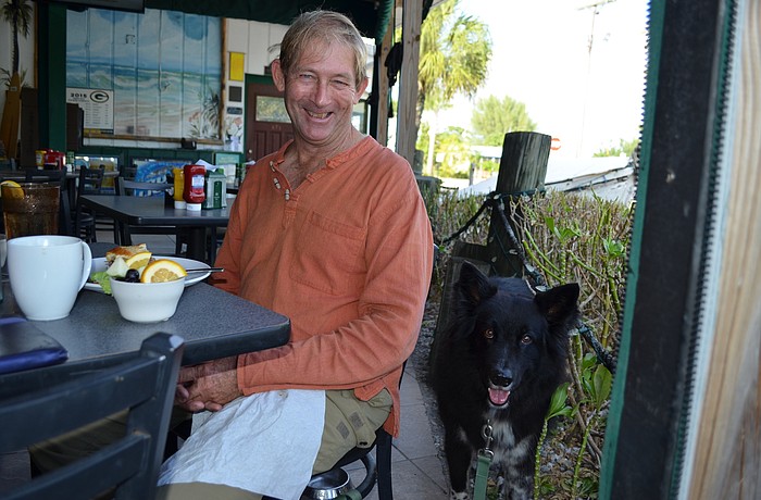 Capt. Wayne Genthner of Wolfmouth Charters has lunch with collie mix AbuJuju, 6, at the Bridgetender Inn on Anna Maria Island Nov. 18.