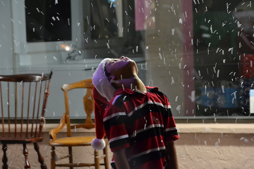 Kayne Peters is mesmerized by the snow drifting down while waiting in line to see Santa Claus.