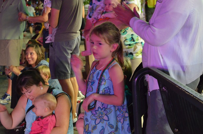 Clara Brown waves to Santa Claus from the curb.