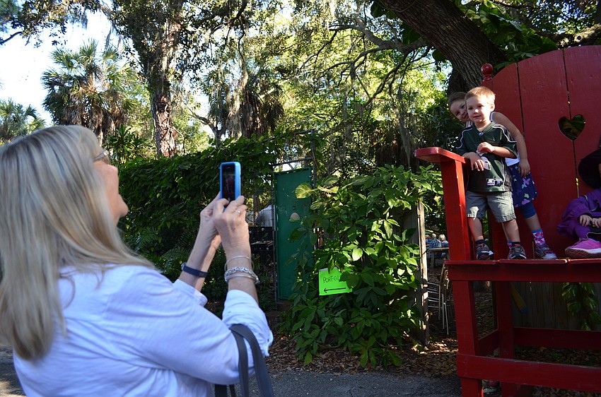 Nancy Greer snaps a shot of Jillian and Zack Haber standing on top of a giant rocking chair.