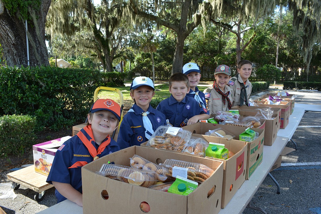 Pack 126 members Andrew Temple, 6, Danny Marino, 8, Patrick Blenker, 8, Aiden Wilson, 8, Ryan Stansbury, 10, and Boy Scout Troop 89's Thomas Stansbury, 11, hand out food at the Manatee Baptist Church.
