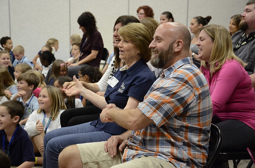 Rose Lopez and Jason Frisbie, a parent, play along during the performance.