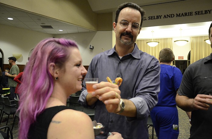 Instructor Joe Askren compares the blueberry blonde ale to student Jordan Bailey's hair.