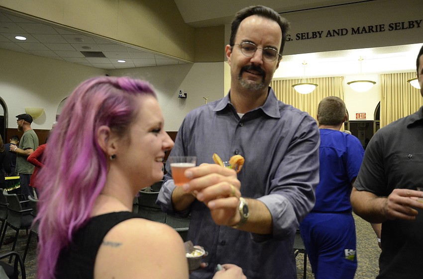 Instructor Joe Askren compares the blueberry blonde ale to student Jordan Bailey's hair.