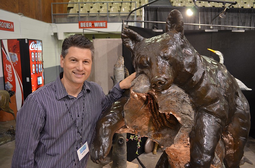 Ben Foster joined by his sleep brown bear wooden piece he completed this summer at the Sarasota Craft Show.